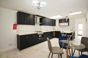 a kitchen with black cabinets and a table and chairs at APod in Coventry
