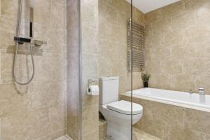 a bathroom with a shower and a toilet and a tub at Heritage Serviced Suites - Serviced Apartments in Huddersfield