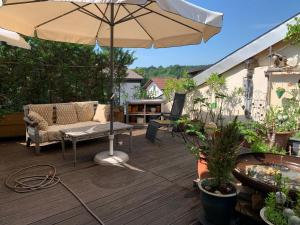 a patio with an umbrella and a couch and a table at Wohnhaus am Marktplatz in Röhrnbach in Röhrnbach