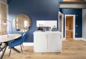 a dining room with a table and a mirror at Heritage Serviced Suites - Serviced Apartments in Huddersfield