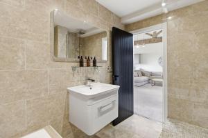 a bathroom with a sink and a shower with a mirror at Heritage Serviced Suites - Serviced Apartments in Huddersfield