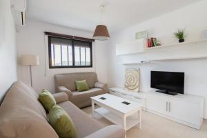 a living room with a couch and a tv at Casa de Los Maestros in Bicorp +3 photos