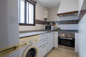 a kitchen with a washing machine and a microwave at Casa de Los Maestros in Bicorp