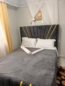 a bed with a black headboard and white pillows at Nalim bliss garden in Ruiru