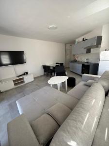 a living room with a couch and a table at Beachside Apartments Novalja in Stara Novalja