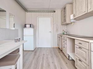 a kitchen with wooden floors and a white refrigerator at Private double room with balcony in Neringa +5 photos