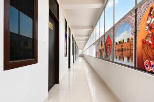 a corridor in a building with paintings on the walls at FabHotel Palak Palace in Jaipur