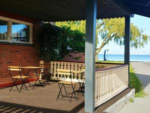 a patio with a table and chairs and the ocean at Private double room with balcony in Neringa