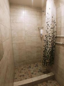 a bathroom with a shower with a tiled floor at Private double room with balcony in Neringa