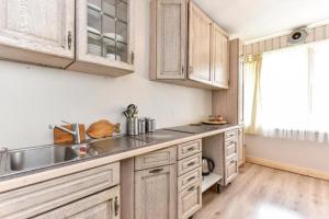 a kitchen with wooden cabinets and a sink at Private double room with balcony in Neringa