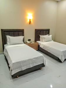 two beds sitting next to each other in a bedroom at The R Hotels Nursery in Karachi