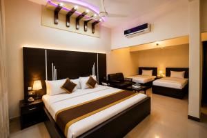 a hotel room with two beds and a desk at The R Hotels Nursery in Karachi
