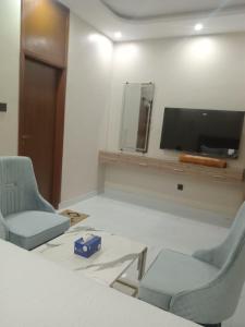 a room with two chairs and a flat screen tv at The R Hotels Nursery in Karachi