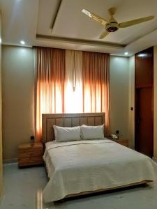 a bedroom with a large bed and a window at The R Hotels Nursery in Karachi
