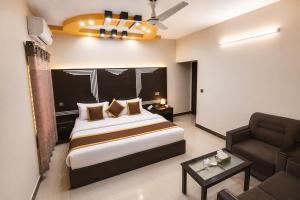 a hotel room with a bed and a couch at The R Hotels Nursery in Karachi