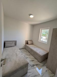 a bedroom with two beds and a window at Beachside Apartments Novalja in Stara Novalja