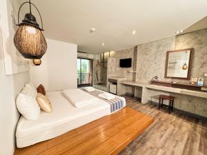 a bedroom with a large bed and a television at Boutique Poo-Yai Lee in Bangkok