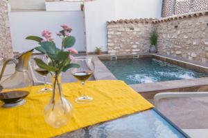 a table with two glasses of wine and a swimming pool at El Prado, 2 in El Mármol