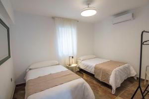a room with two beds and a window at El Prado, 2 in El Mármol +14 photos