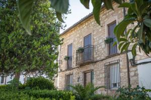 an old stone building with windows and plants at El Prado, 2 in El Mármol