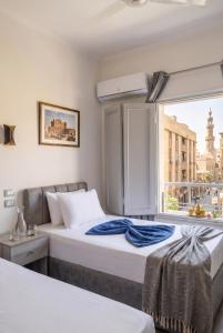 two beds in a room with a window at Parque Praca hotel in Cairo