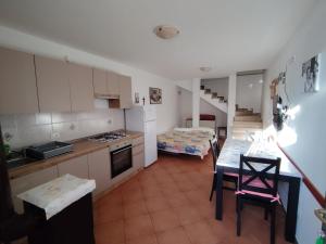 a kitchen with a table and a room with a bed at Apartments Ana Pogana in Punta Križa +18 photos