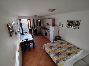 a room with a bed and a kitchen with a table at Apartments Ana Pogana in Punta Križa