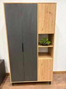 a wooden book shelf with a plant on it at La Luna Apartman in Bečej