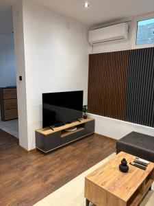 a living room with a flat screen tv and a coffee table at La Luna Apartman in Bečej
