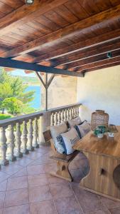 a porch with a bench and a table with pillows at Villa Punta in Rovanjska