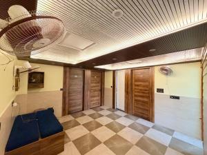 a room with a ceiling fan and a checkerboard floor at Hotel Elite Inn in Dehradun
