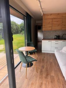 a room with a table and chairs and a kitchen at Wiatrowe Domki in Lądek-Zdrój