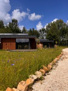 a modern house with a garden and a gravel road at Wiatrowe Domki in Lądek-Zdrój