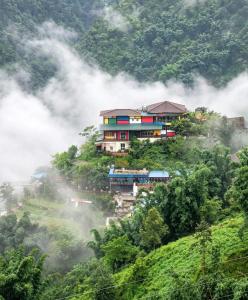 a house on top of a hill in the clouds at Elephant homestay in Sapa