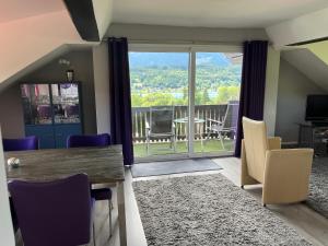 a living room with a table and chairs and a balcony at Ferienwohnung Amselnest in Seeboden
