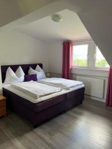 a bedroom with a large bed with purple curtains at Ferienwohnung Amselnest in Seeboden