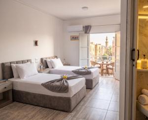 two beds in a hotel room with a balcony at Parque Praca hotel in Cairo +10 photos