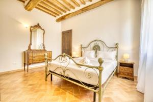 a bedroom with a bed and a dresser and a mirror at Podere Montale Winery in Seggiano