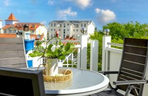 a patio table with a potted plant on a balcony at Ferienwohnung Rafaela in Zinnowitz