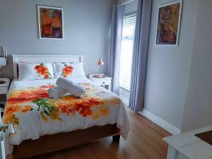 a bedroom with a bed with a flower blanket at 501 Beach Club in Mossel Bay +9 photos
