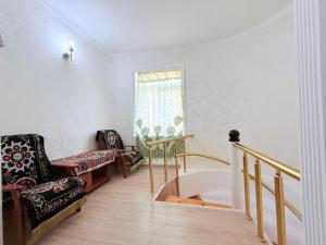 a room with a bath tub and a chair at Ismat Premium Guest House in Bukhara