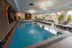 a swimming pool in a living room with chairs and a couch at Brick House in Borşa