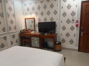 a bedroom with a bed and a desk with a television at THANH TAI HOTEl 1 in Ho Chi Minh City