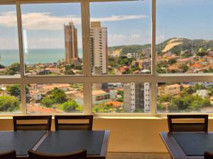 a room with tables and chairs in front of a window at Bali Mar Hotel in Natal