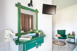 a green dresser with a mirror and a green chair at Pavlos Maria studios in Skiathos