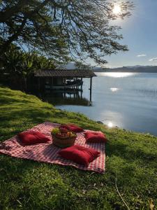 a picnic blanket on the grass next to the water at paraiso da lagoa in Imbituba