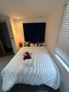 a large white bed with a bouquet of flowers on it at Echelon Executive suite 1 in Bradford