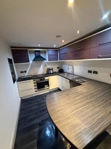 a kitchen with purple cabinets and a wooden table at Echelon Executive suite 1 in Bradford +6 photos