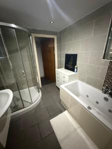 a bathroom with a tub and a shower and a sink at Echelon Executive suite 1 in Bradford
