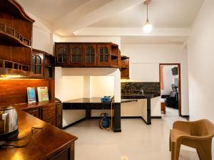 a kitchen with wooden cabinets and a counter top at Namali Guest House in Badulla